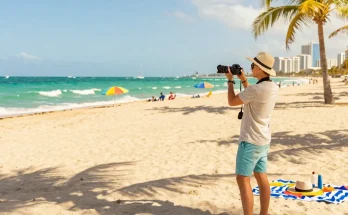 Pengunjung menikmati pantai Miami di https://miami4d.com/, berpakaian santai, menikmati sinar matahari dan suasana tropis.
