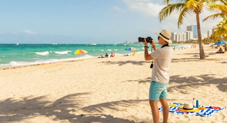 Pengunjung menikmati pantai Miami di https://miami4d.com/, berpakaian santai, menikmati sinar matahari dan suasana tropis.